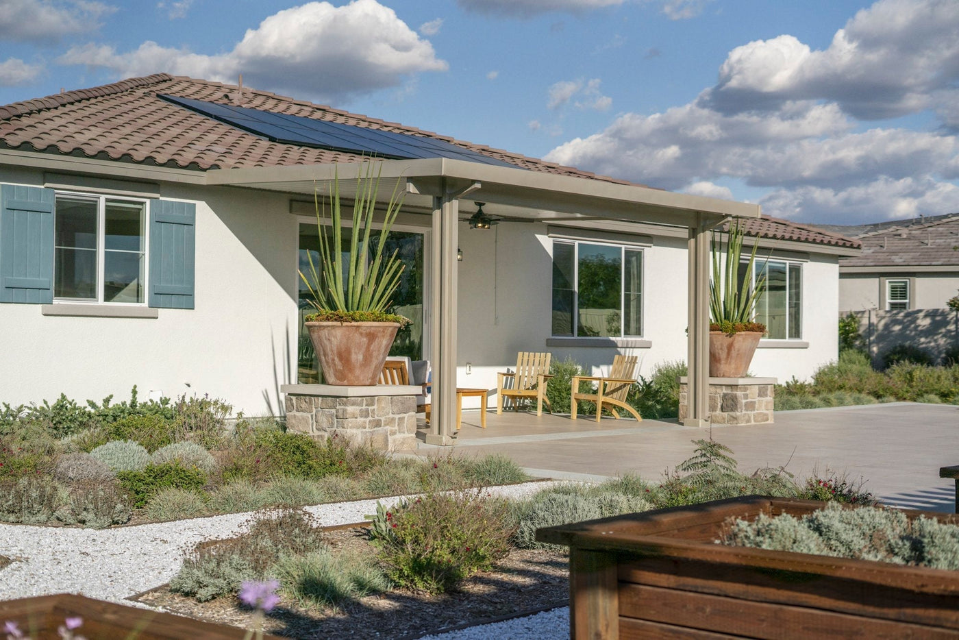 Home with solar panels and an attached patio cover in a desert climate