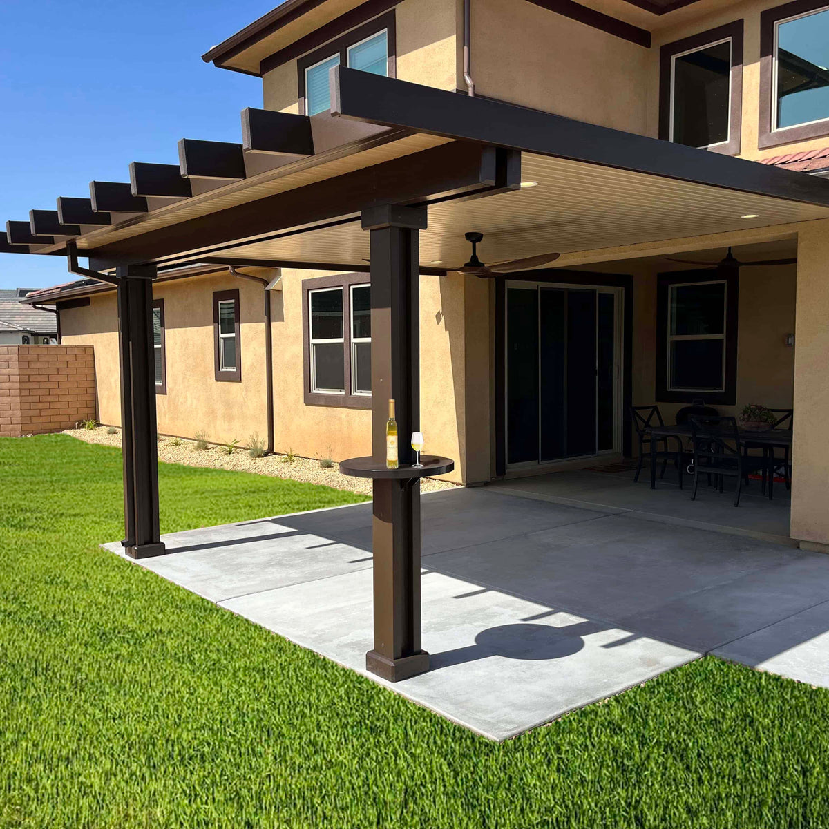 Brown patio cover with grass backyard. An alumatable is installed on the patio cover post