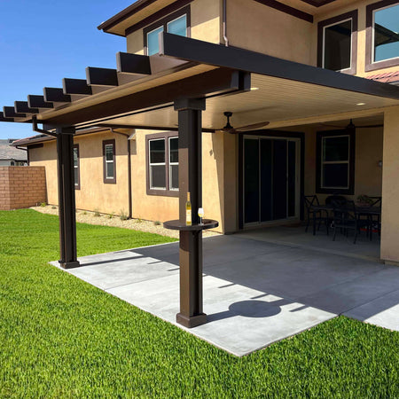 Brown patio cover with grass backyard. An alumatable is installed on the patio cover post