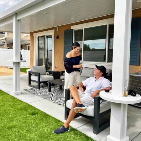 Couple relaxing on their patio with an Alumatable holding their drinks